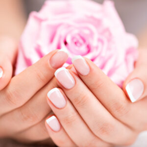 Beautiful woman's nails with beautiful french manicure  and pink rose